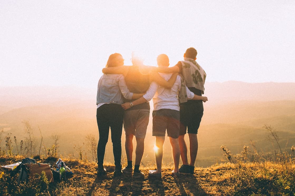 A group of travelers watching a sunset together